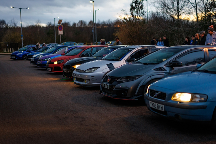 Row of cars lined up in a UK car park at dusk