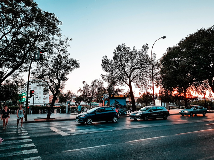 Coches esperando en un semáforo en una calle al atardecer