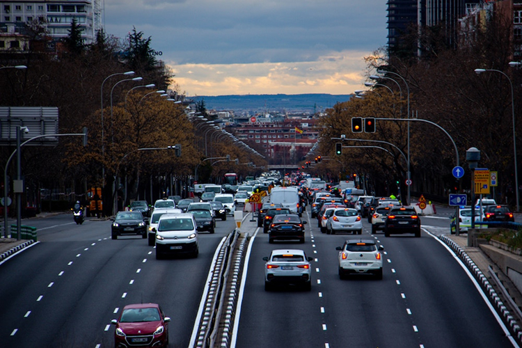 Tráfico denso en una avenida de Madrid al atardecer